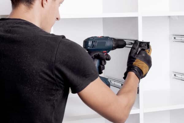 furniture maker sets telescopic rails on the cabinet