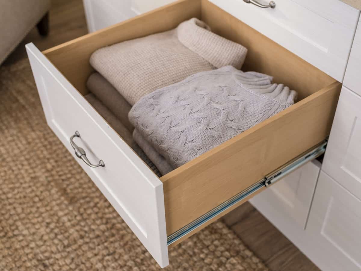 Dresser drawer pulled out with folded clothing inside