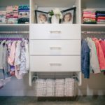 Children's closet full of shoes on shelves and clothing on shelves and hung up on racks