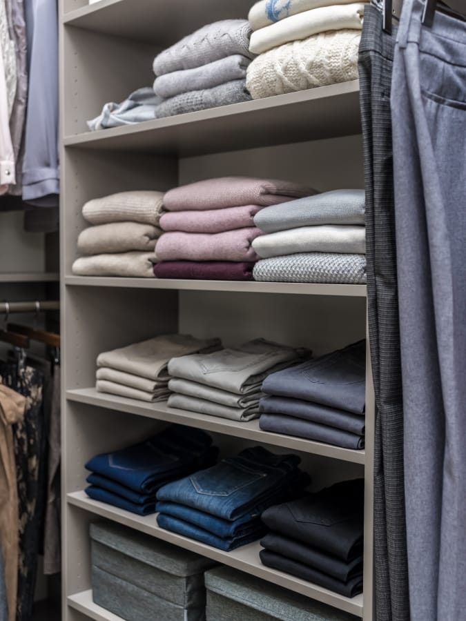 Clothing folded on shelves in closet