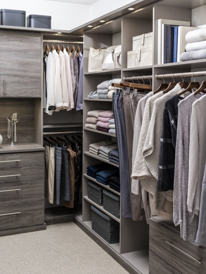 Closet filled with clothing on racks and placed on shelves