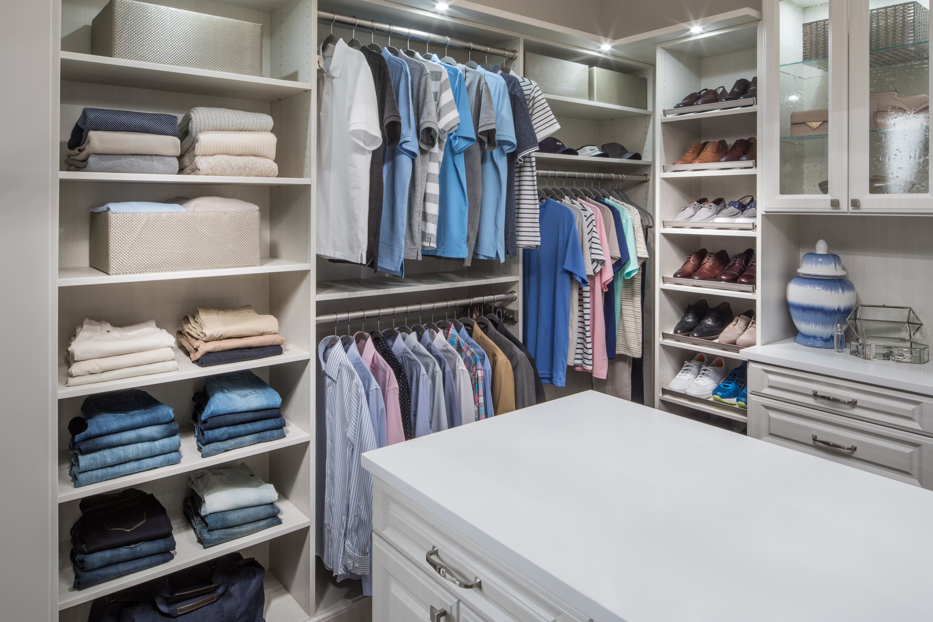 Boutique closet with clothing on shelves, in racks, and in drawers and cabinets