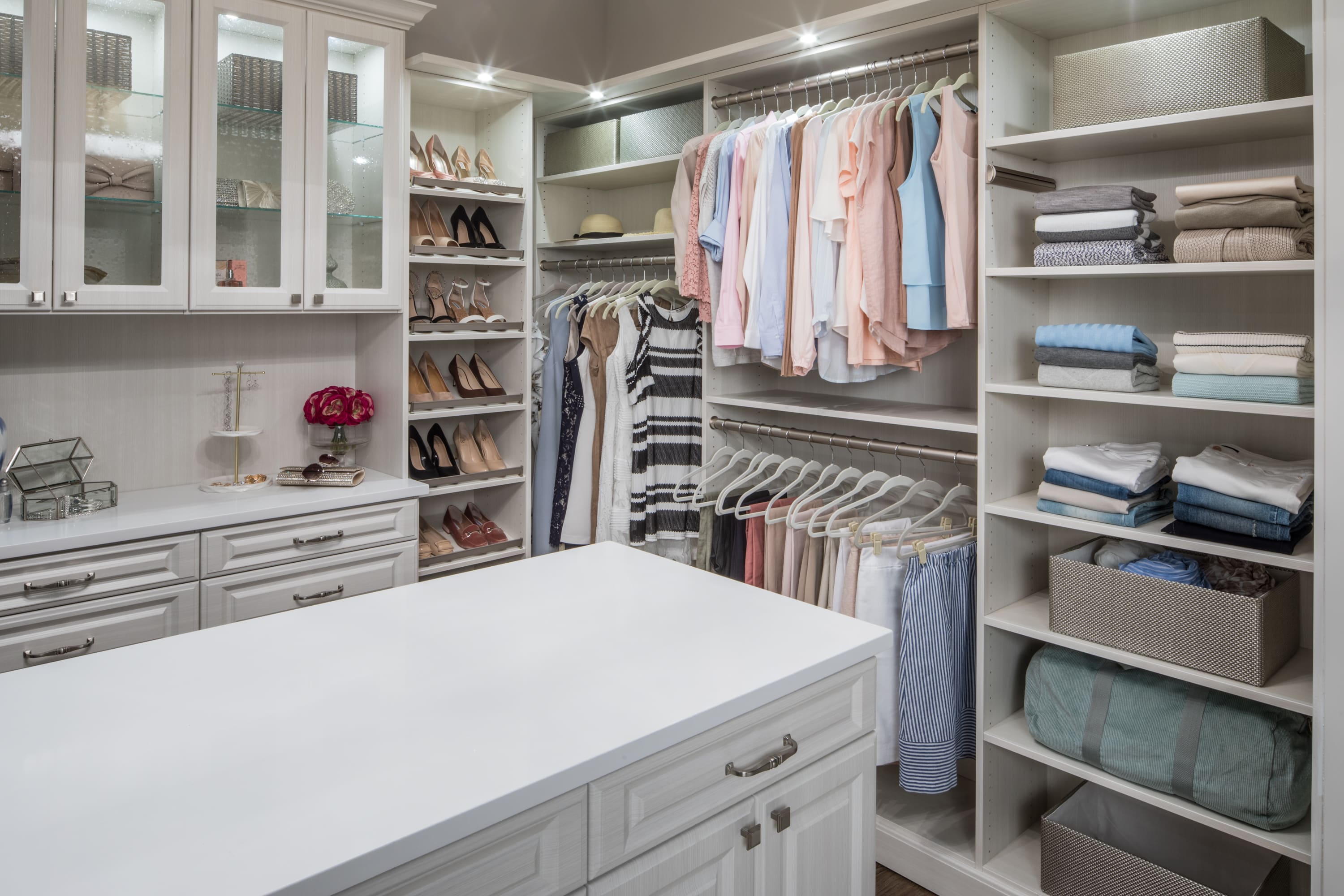 Boutique closet with clothing on shelves, in racks, and in drawers and cabinets
