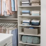 Clothes and other articles on shelves with shirts and pants hung on racks