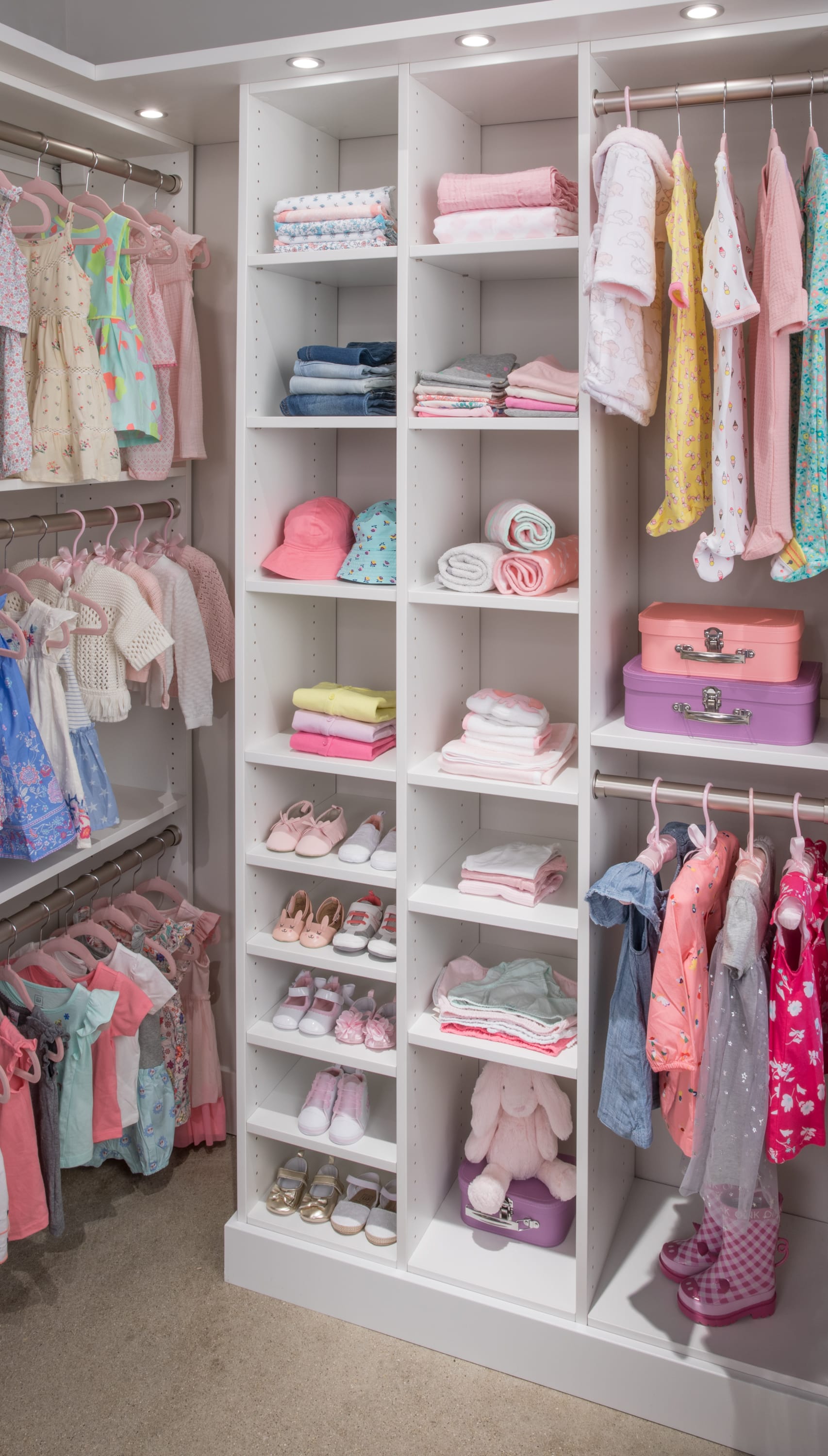 Girls walk in closet with clothing on racks and shelves