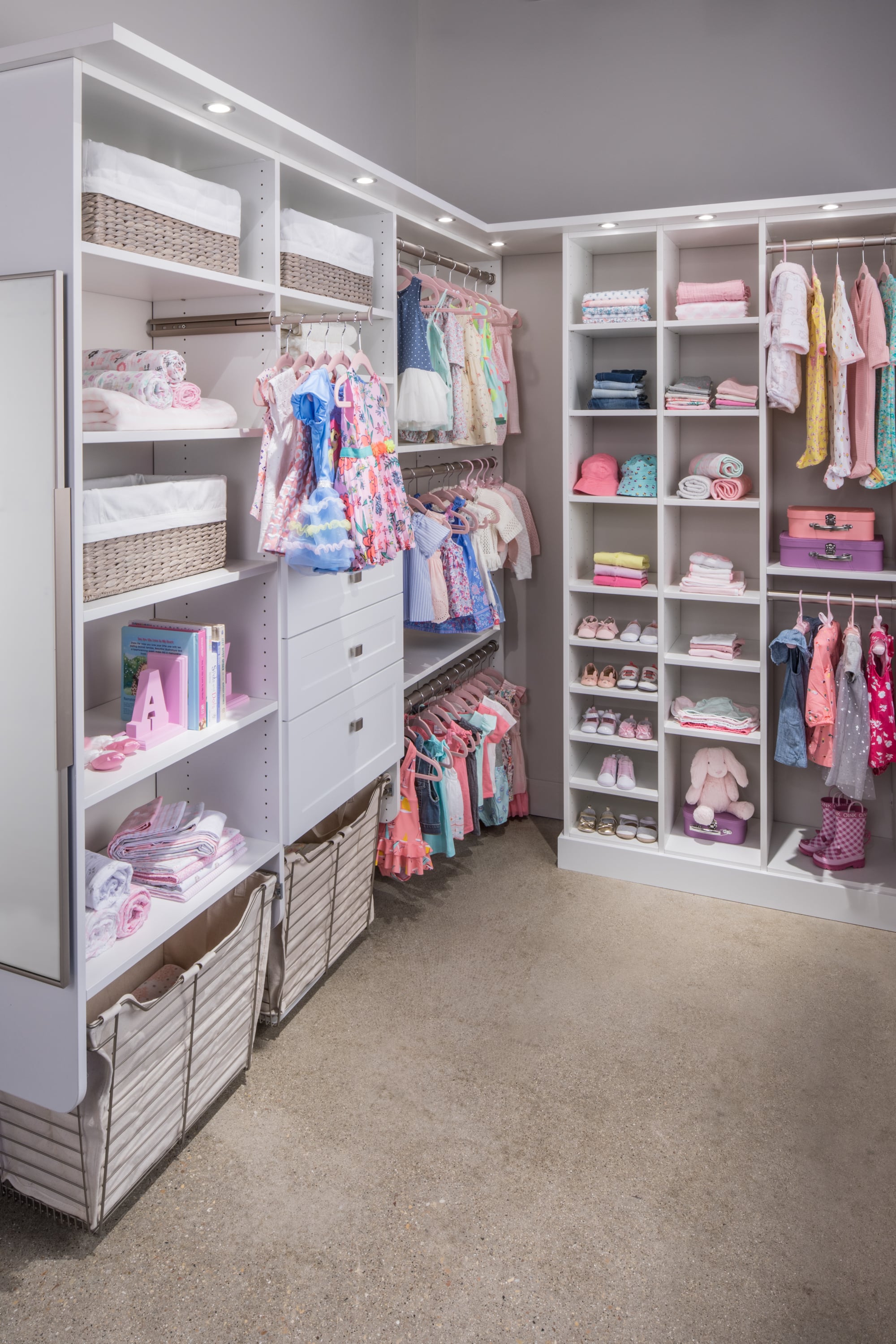 Girls walk in closet with clothing on racks and shelves