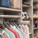 Close up of closet with clothing rack, shoes on shelves and hand bags on shelves