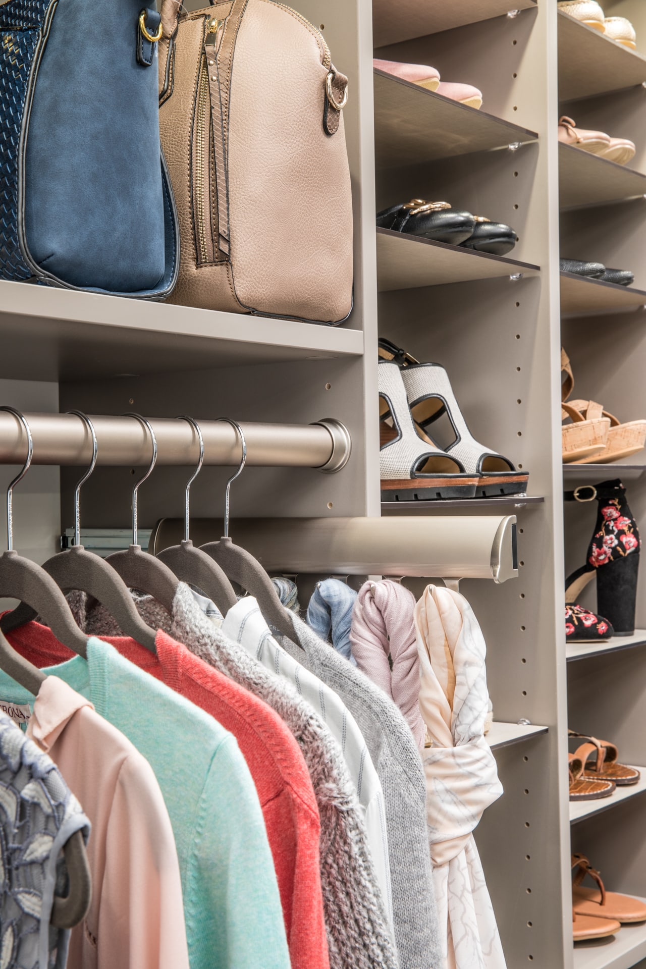 Close up of closet with clothing rack, shoes on shelves and hand bags on shelves