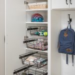 Entryway closet with racks pulled out for personal belongings