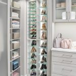 Corner view of closet showing clothing on shelves and shoes on glass shelves