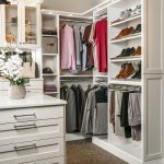 Corner view of closet with shoes on shelves, clothing on racks and other articles in cabinets