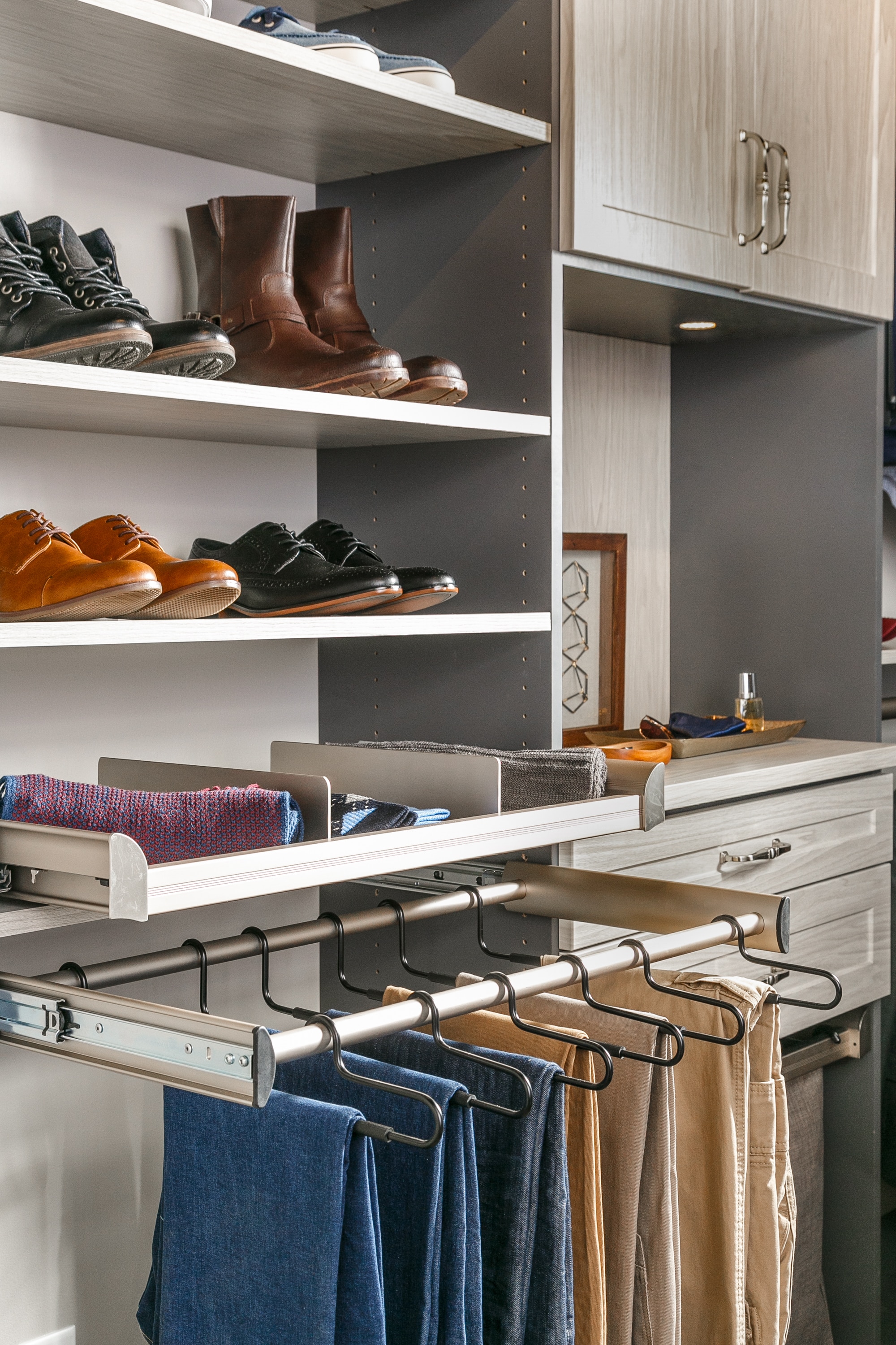 Side view of shoes and socks on shelves as well as pants hung on clothing racks