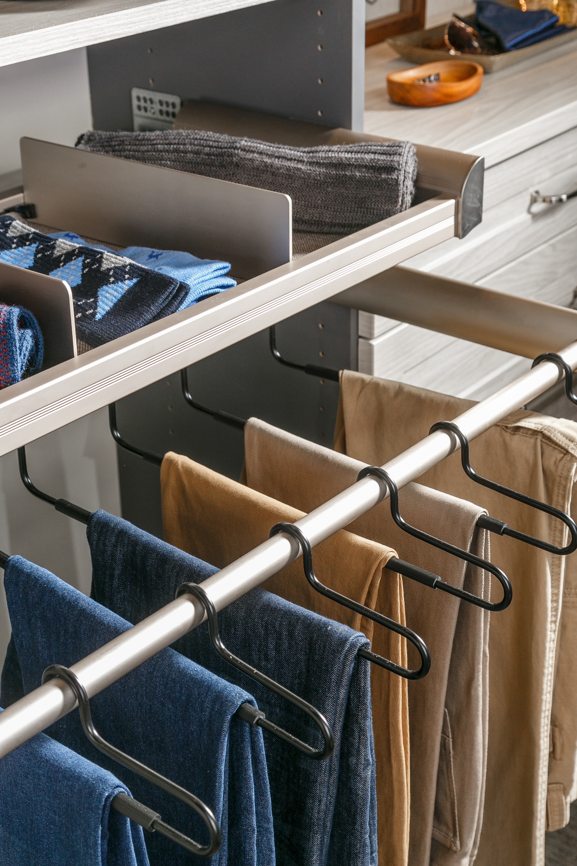 Close up of pants hung up on rack in closet