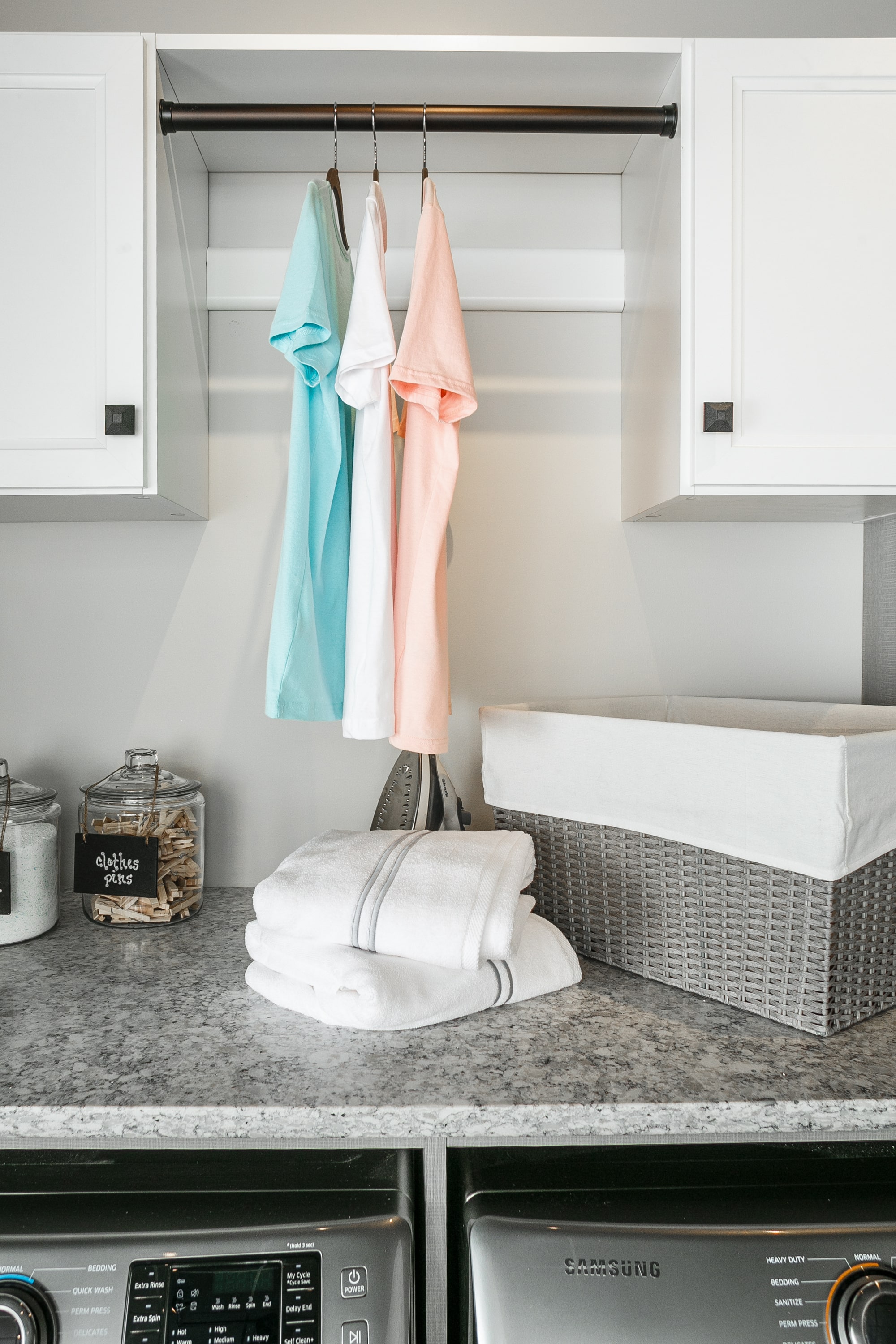 Laundry closet showing rack for hanging clothing