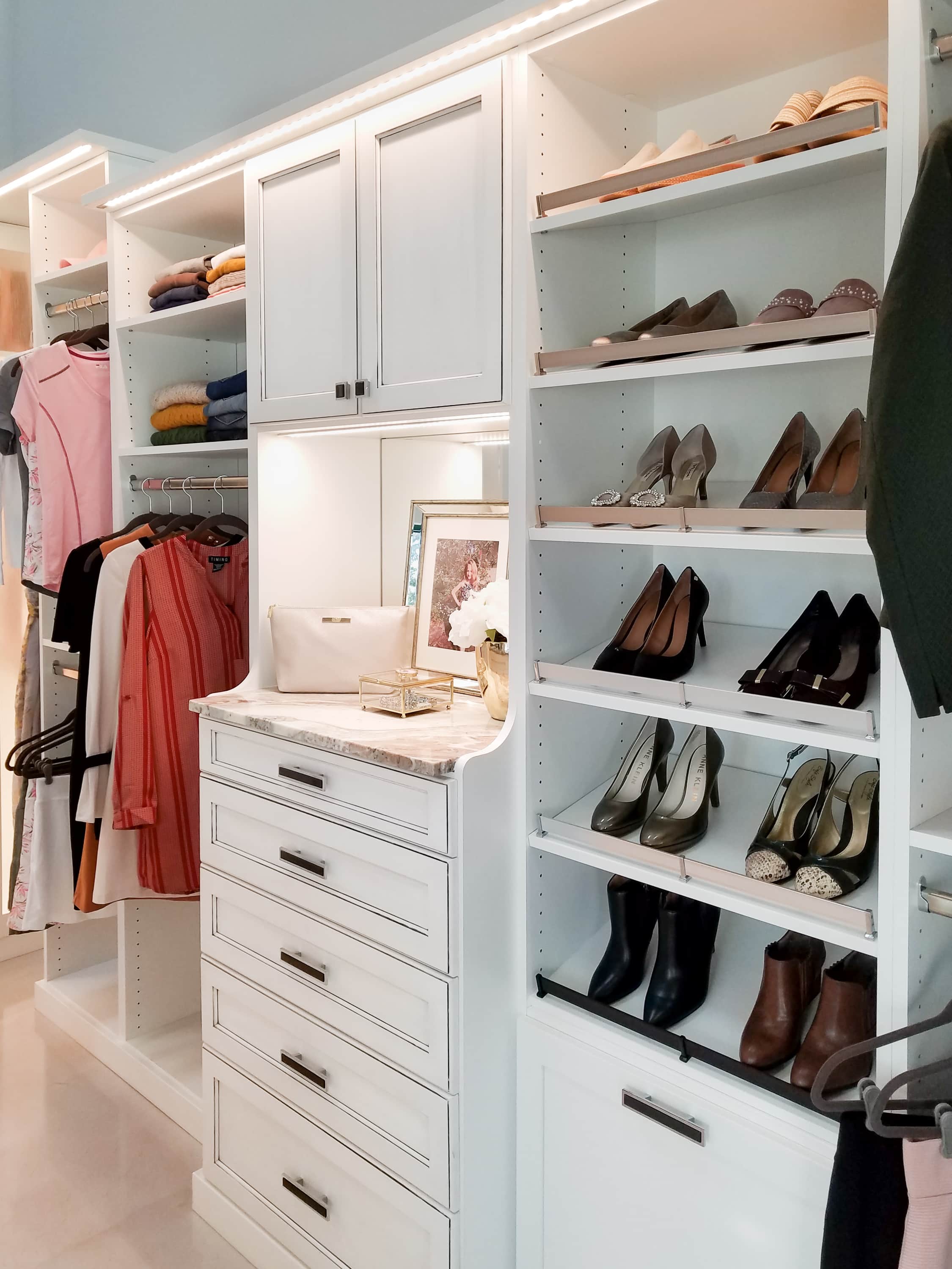 Closet showing women's shoes on shelves and clothing on shelves and racks