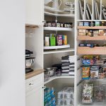 Custom white walk in, floor mount pantry with built in drawers and pull out store in Naples, FL