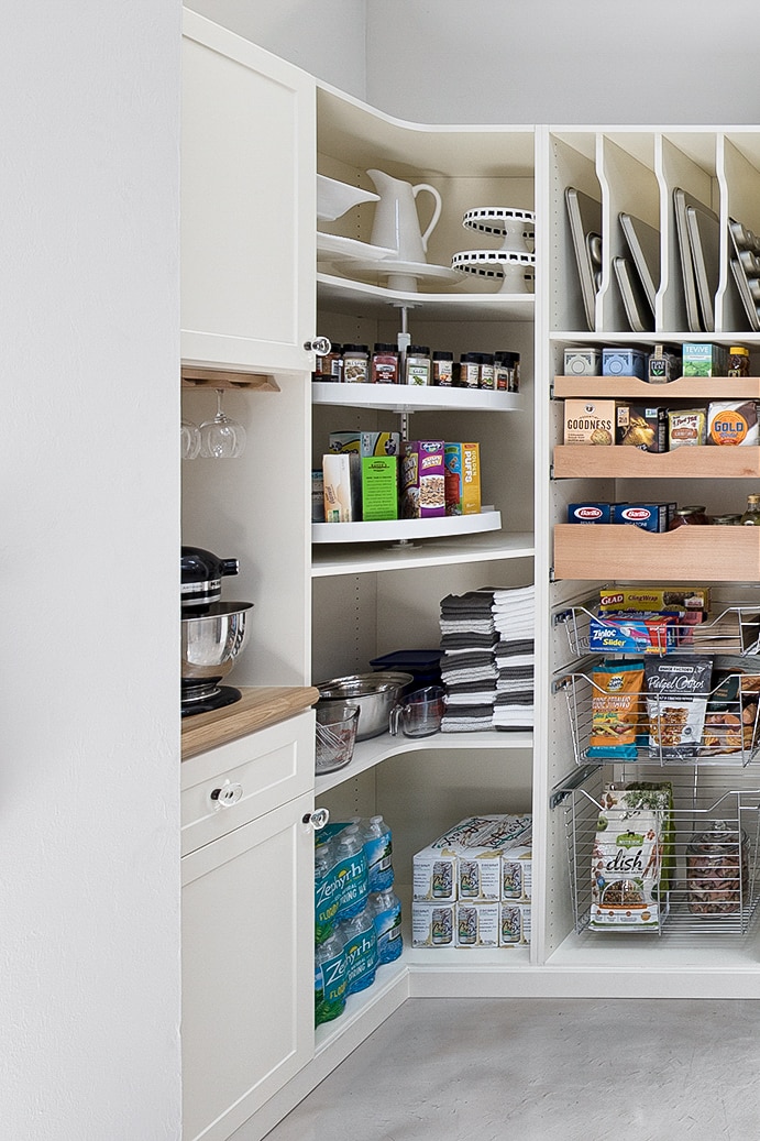 Custom white walk in, floor mount pantry with built in drawers and pull out store in Naples, FL