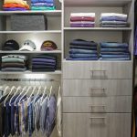 Close up of Inspired Closets closet with shelves, drawers and a clothing rack