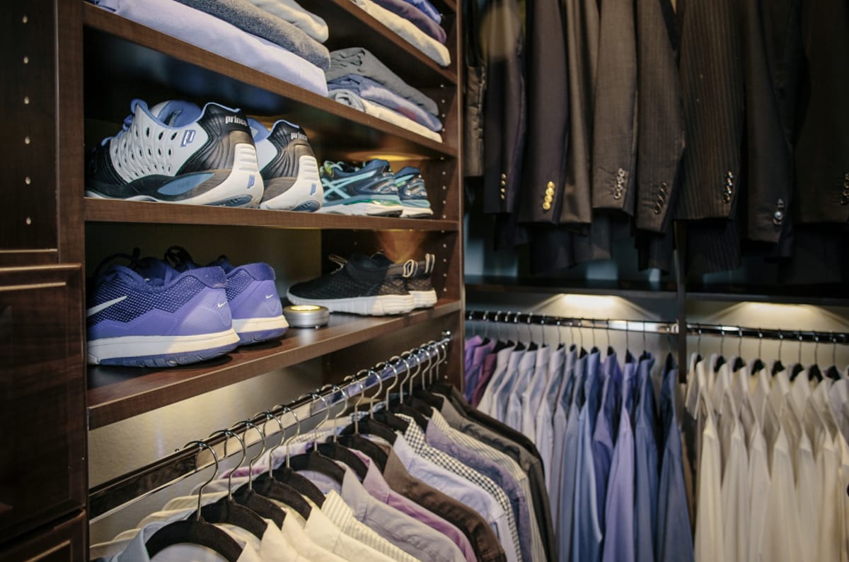 Close up of Inspired Closets closet with shoes on shelves and shirts on clothing racks
