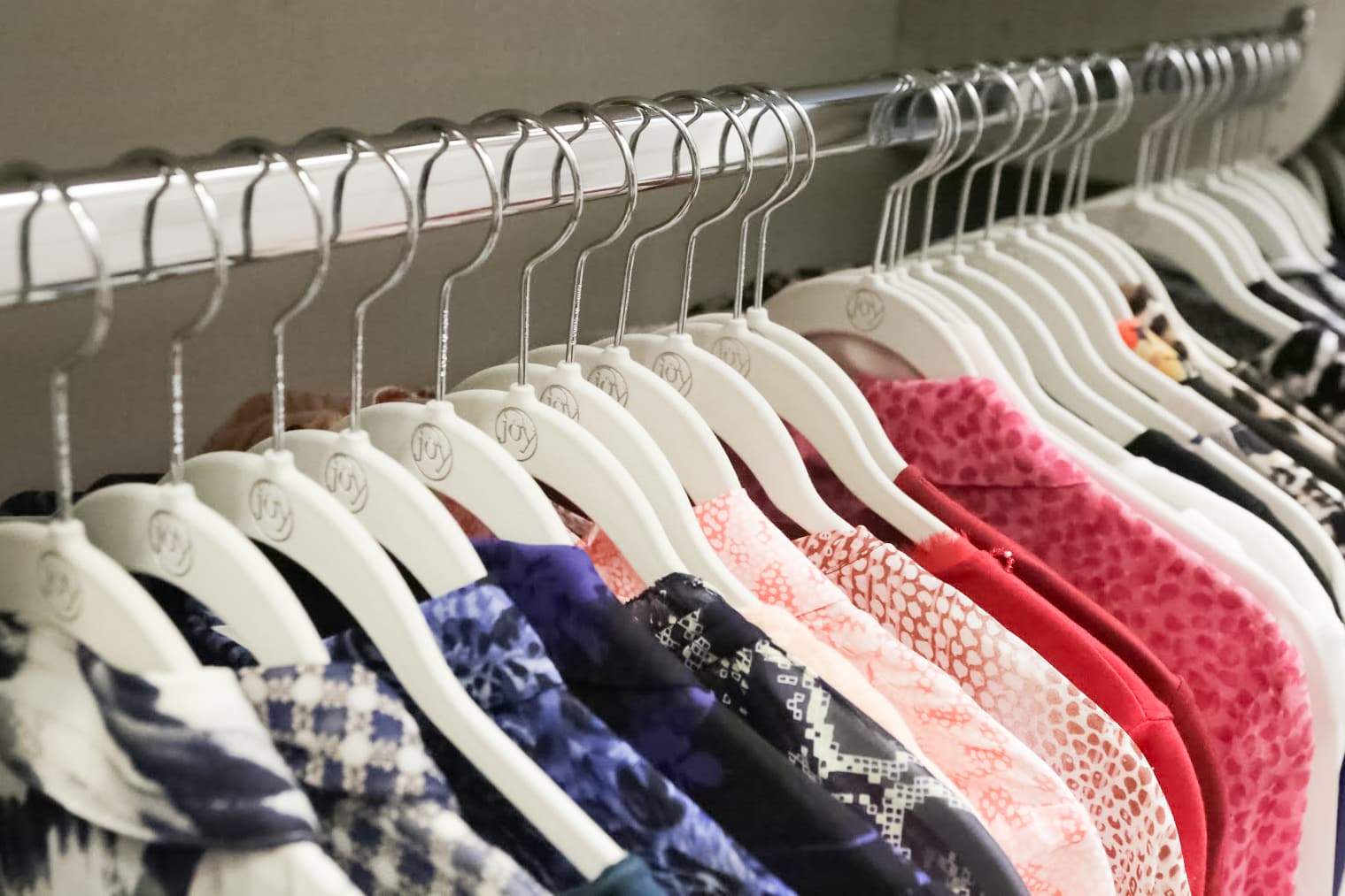 Close up of Inspired Closets closet with clothes on clothing rack