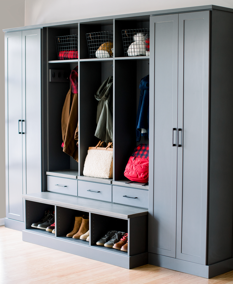 Grey custom mudroom storage with shoe storage, bench and hutches