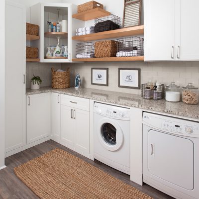 Custom build white laundry room with floating shelves and lazy susan