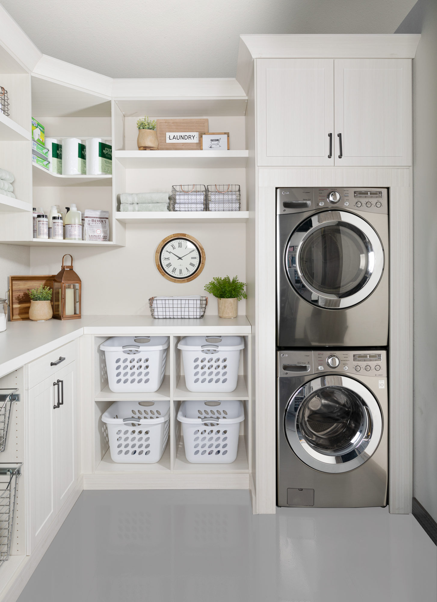 Custom floor mounted boutique laundry room storage with shelving and hampers