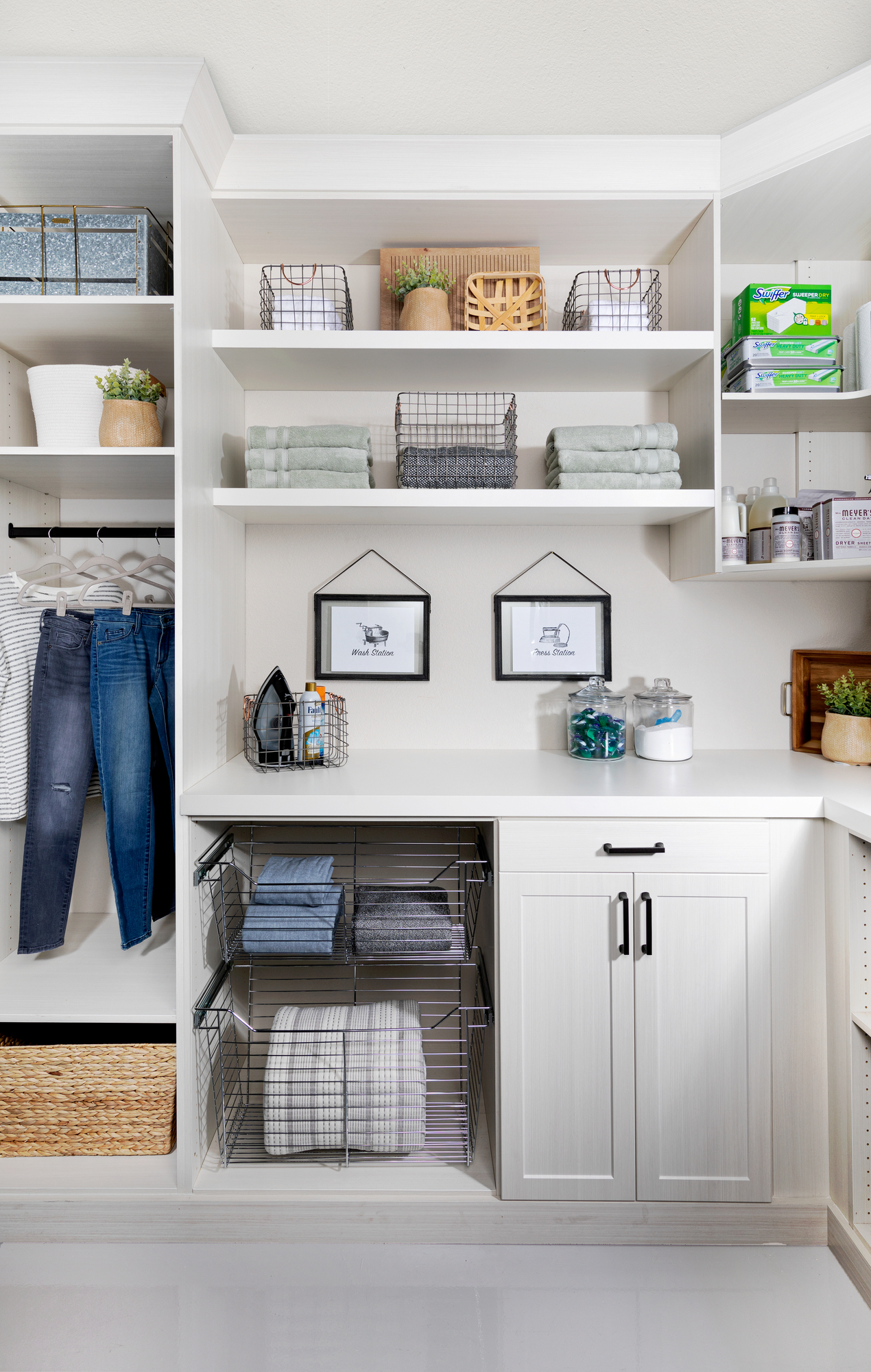 Custom floor mounted boutique laundry room storage with pull out hampers