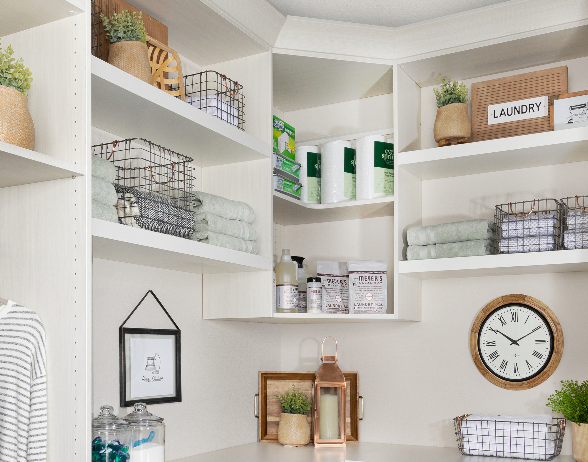 Custom floor mounted boutique laundry room storage with corner shelving