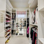 Custom boutique closet with plenty of shoe storage and lighting in Oklahoma City