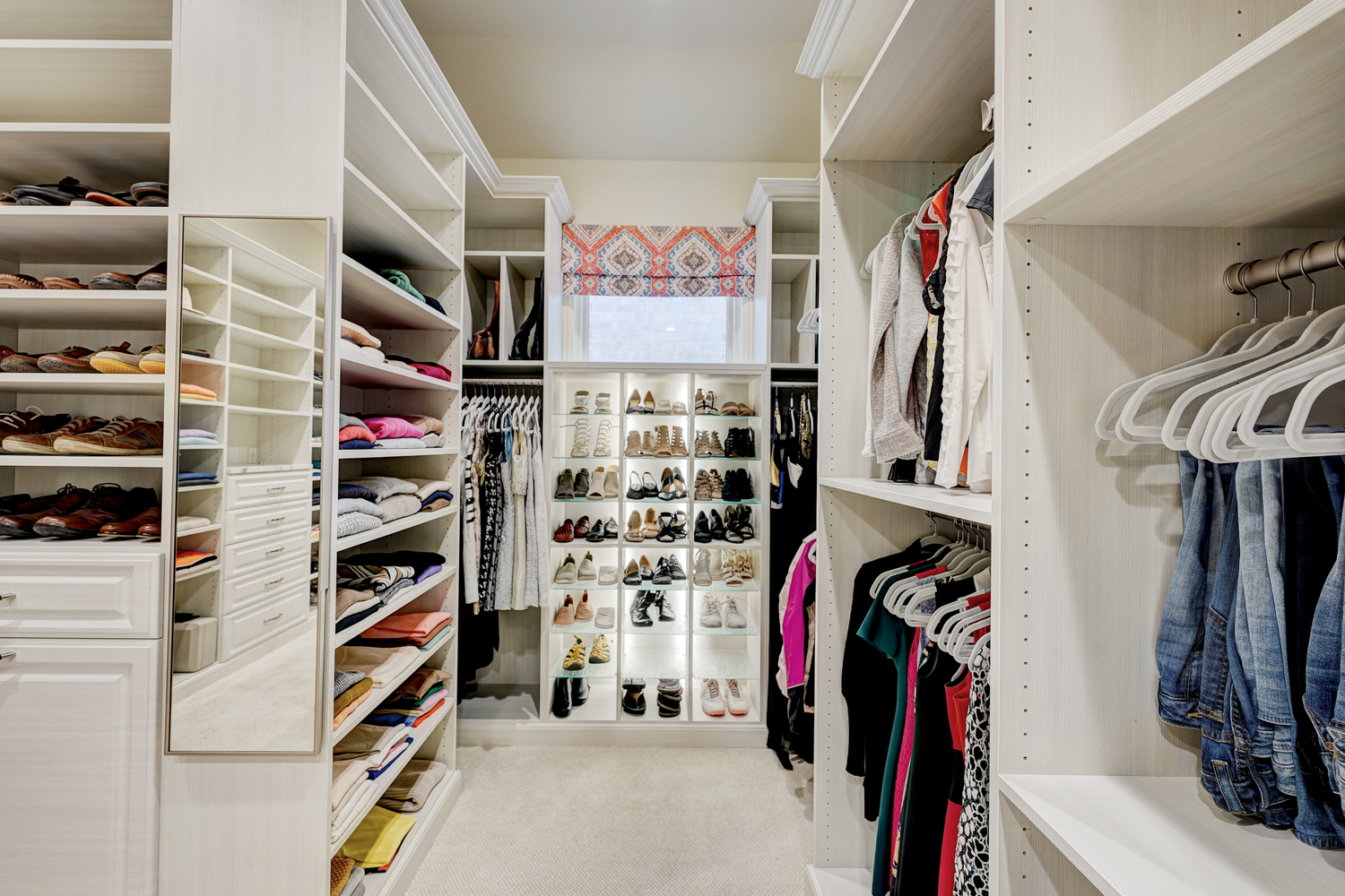 Custom boutique closet with plenty of shoe storage and lighting in Oklahoma City