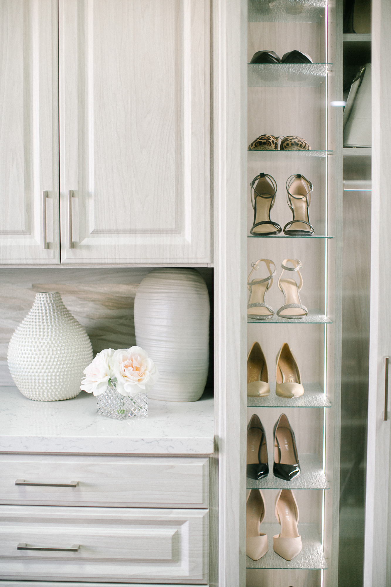 Beautiful floor mounted closet with glass door wardrobe to store shoes in Sacramento