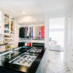 Custom boutique closet island with glass storage and lighting in Sacramento