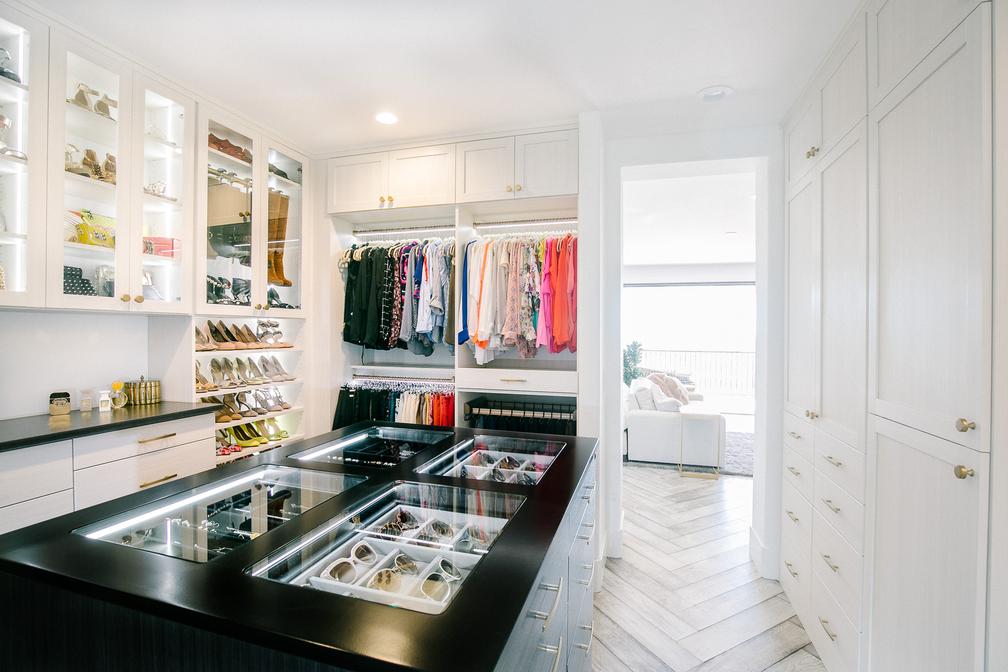 Custom boutique closet island with glass storage and lighting in Sacramento