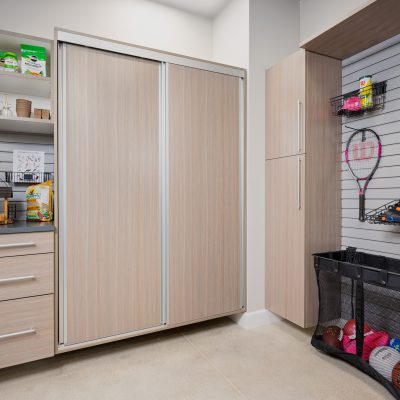Custom wall mounted garage storage in driftwood with sliding cabinet doors in Vero Beach, Florida